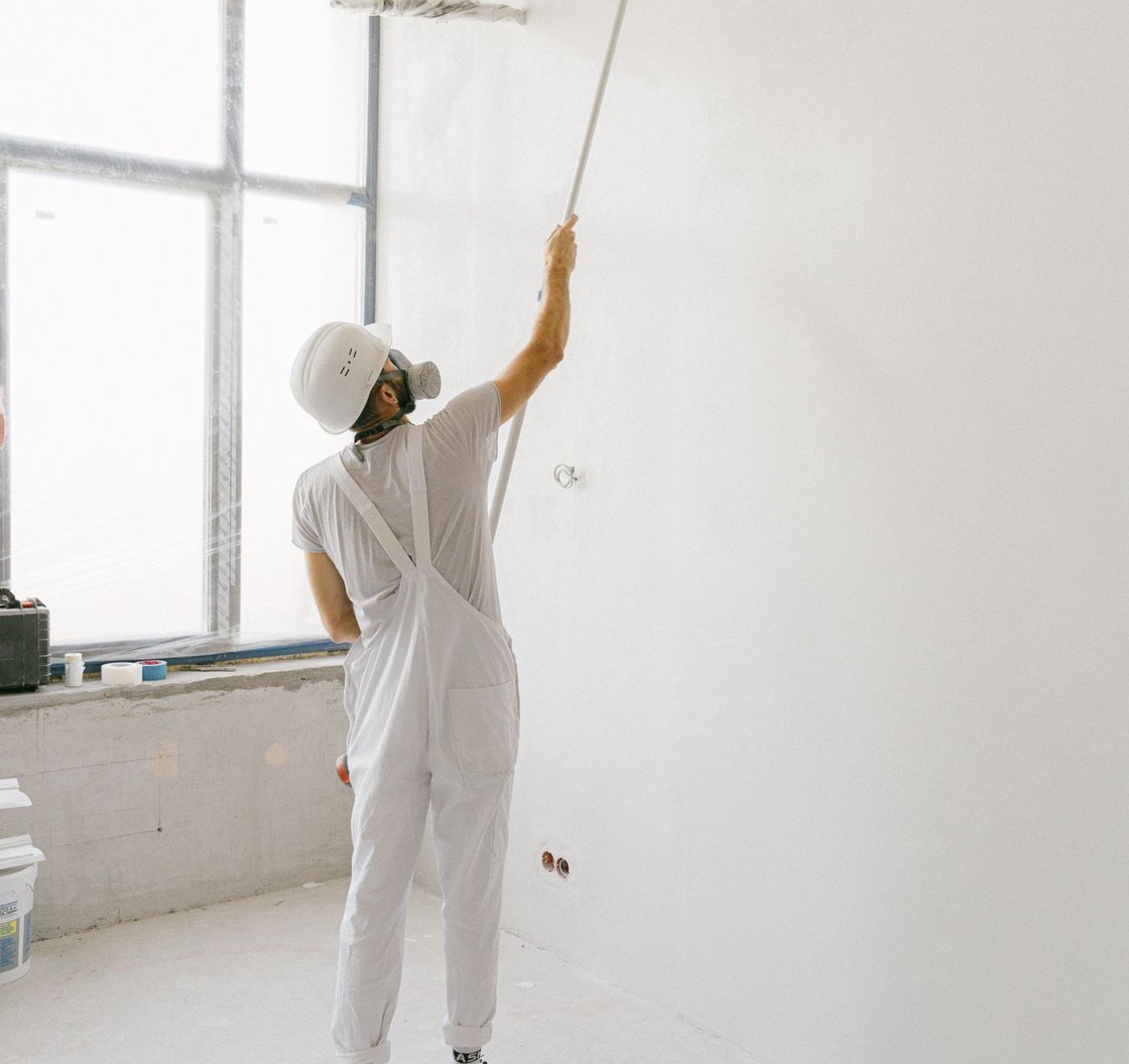 Professional painter carefully painting beside a window