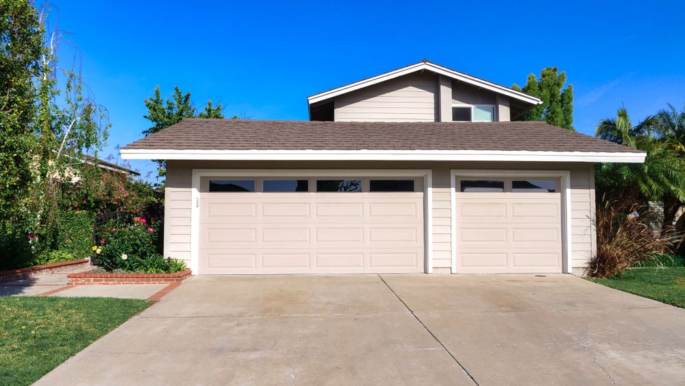 Freshly painted stucco home and garage with clean contrasting trim